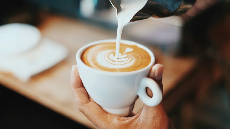 Barista sirviendo leche en un latte